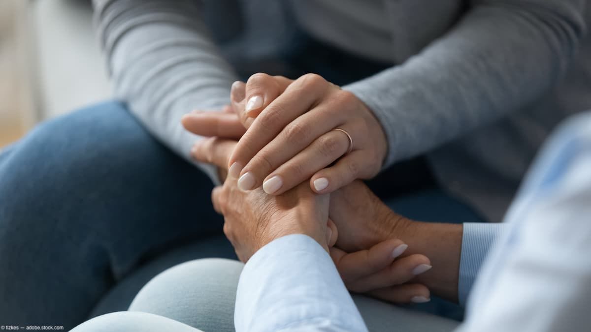 Two people holding hands in supportImage credit: AdobeStock/fizkes