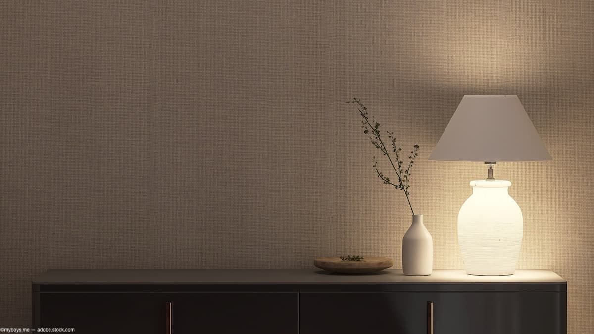 illuminated lamp resting on sideboard (Image credit: AdobeStock/myboys.me)
